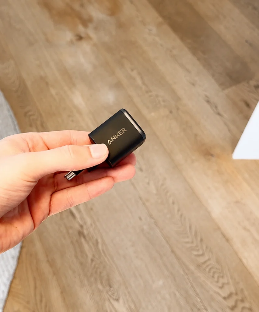 Hand houdt een zwarte Anker Nano-oplader vast